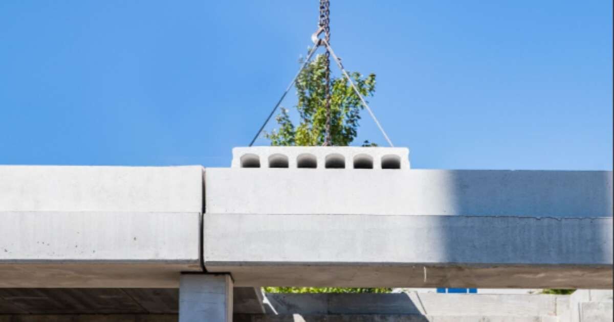 Crain placing a concrete slab onto a concrete beam 